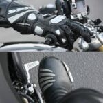 Photograph of a motorcyclist's gloved hand on the front brake and booted foot on the rear brake