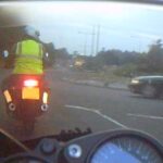 Motorcycle at roundabout with car