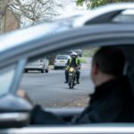 Motorcycle approaching car at junction
