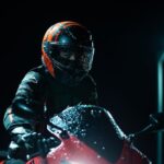 Motorcycle rider in red helmet and black jacket on red motorbike