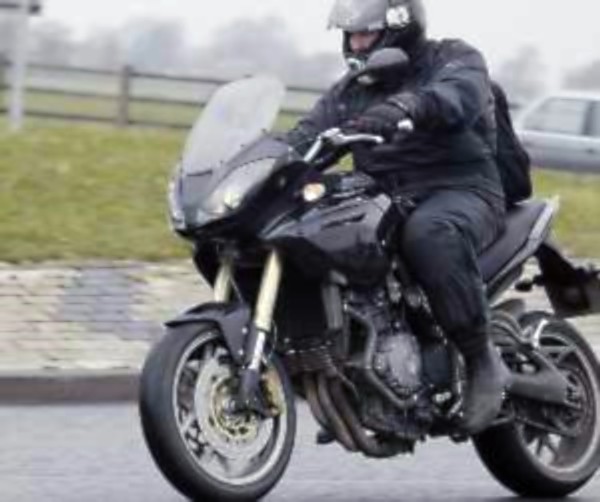 Motorcyclist riding motorcycle with locked elbows